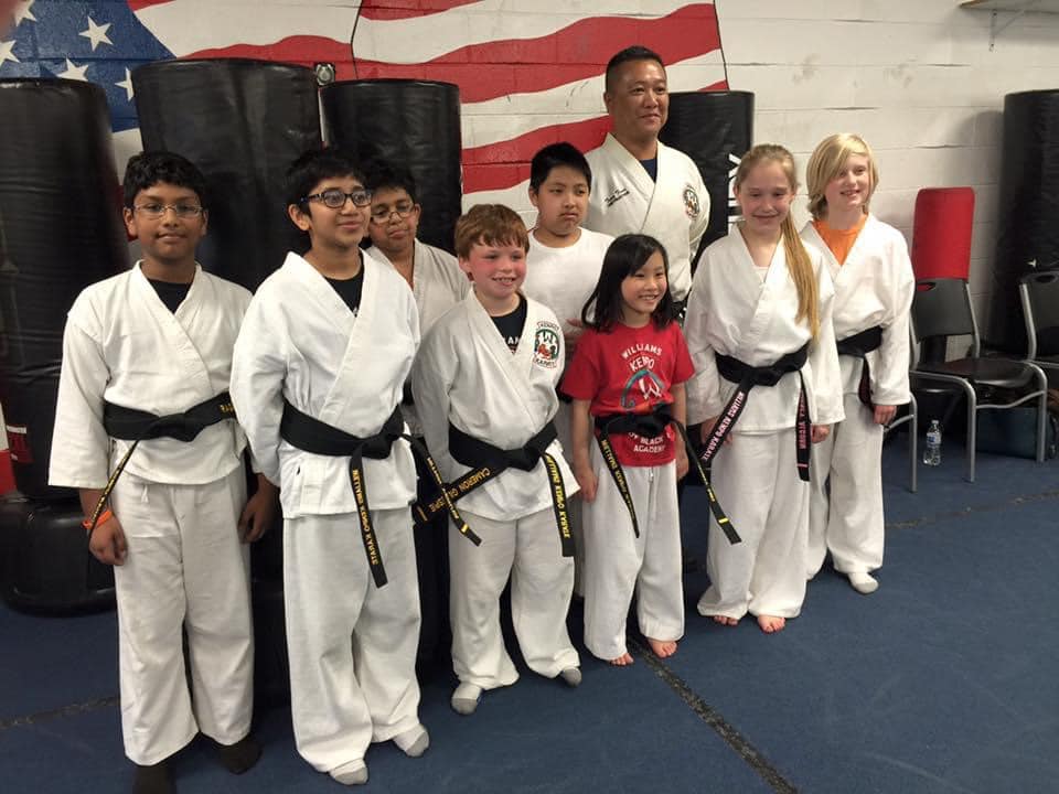 Adult and teen black belt students with their instructor