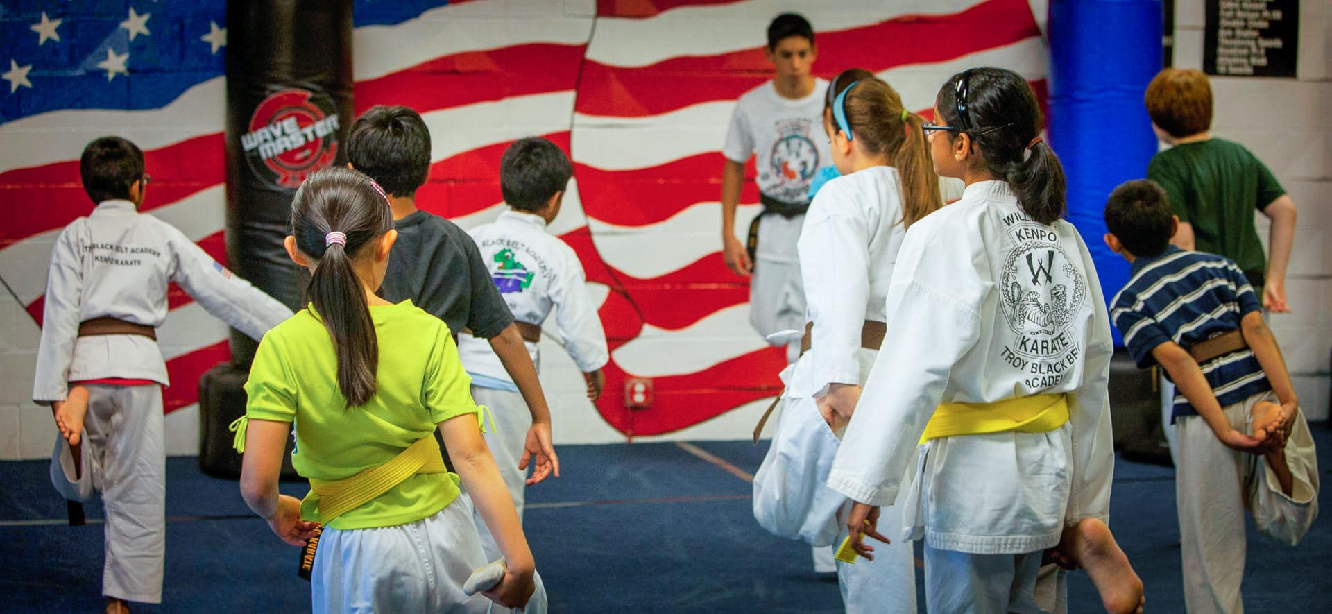 Kids during a warm up before beginning a Karate class at Troy Black Belt Academy